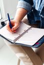 image d'un agenda ouvert avec une personne en train d'ecrire pour illustrer les phrases à écrire et à se répéter pour être efficace au travail malgré les symptomes de la perimenopause