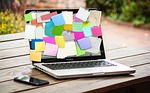 post-it couvrant entierement un ecran d'ordinateur pour illustrer le besoin de noter les taches au travail après 45 ans pendant la périmenopause